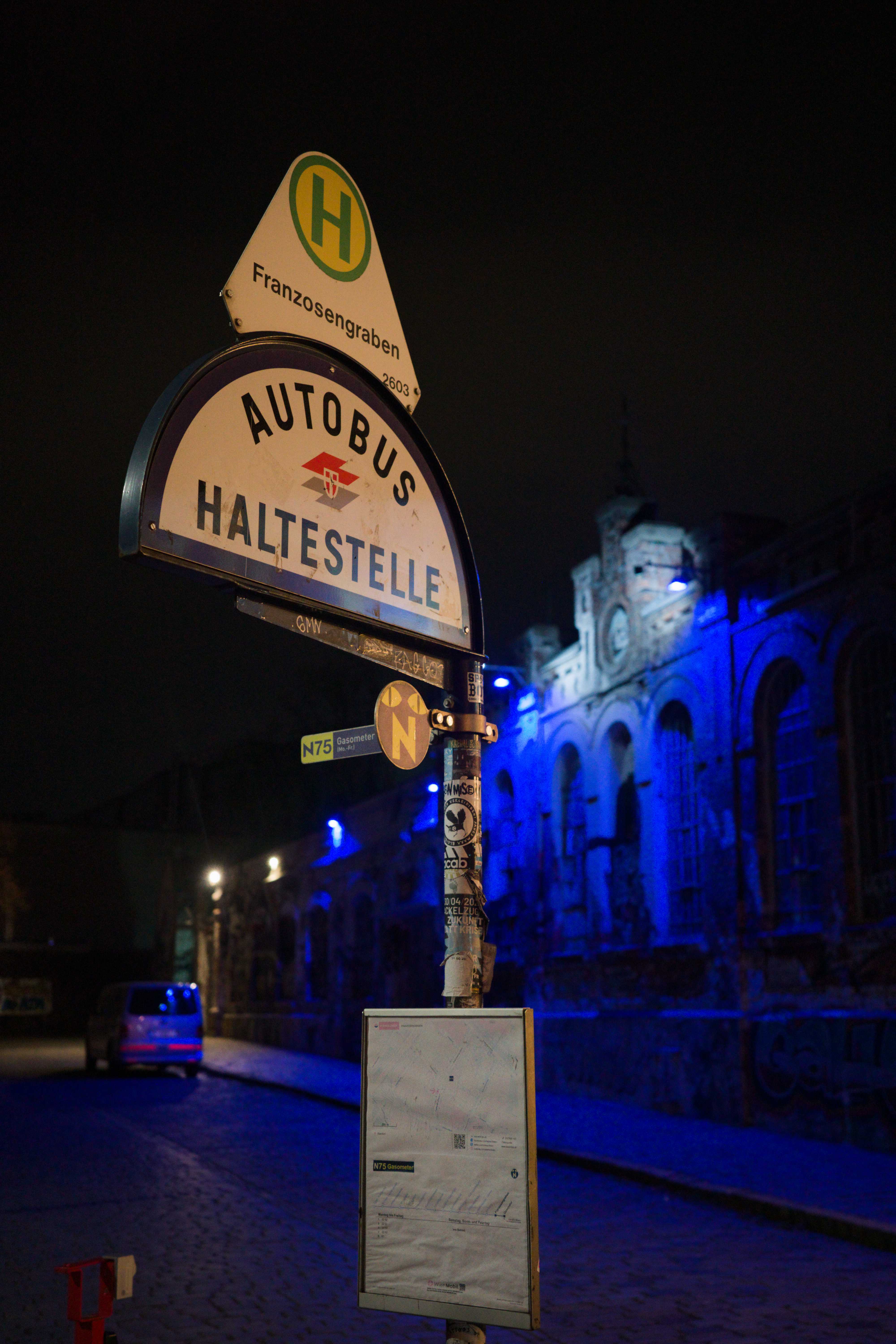 Bushaltestellenschild und Theater im Hintergrund