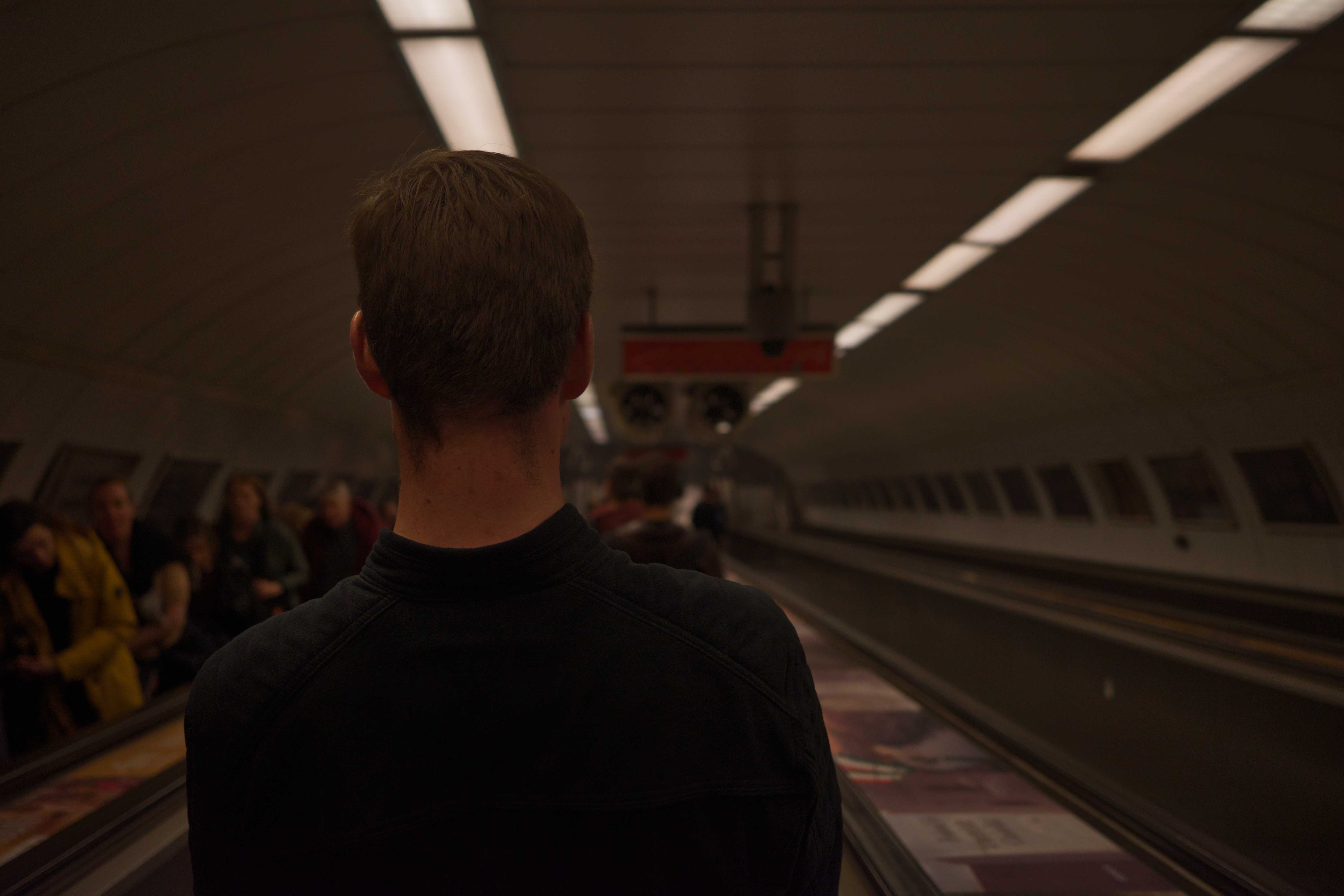 Person auf Rolltreppe auf demWeg in eine Metro Station